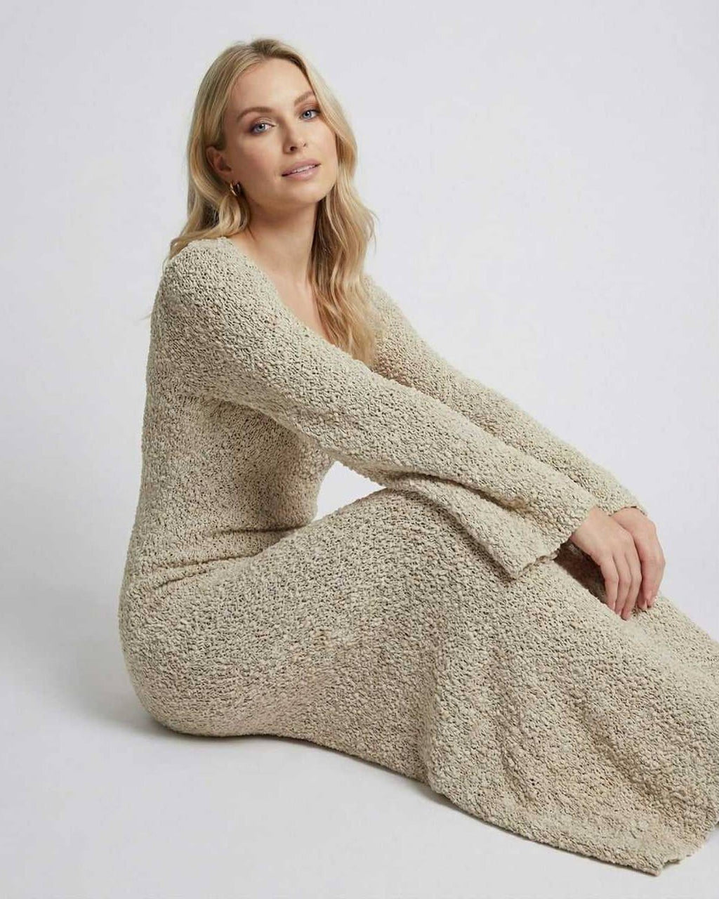 Model wearing Sienna Maxi Dress by Lauven, a beige maxi sweater dress with long flare sleeves.