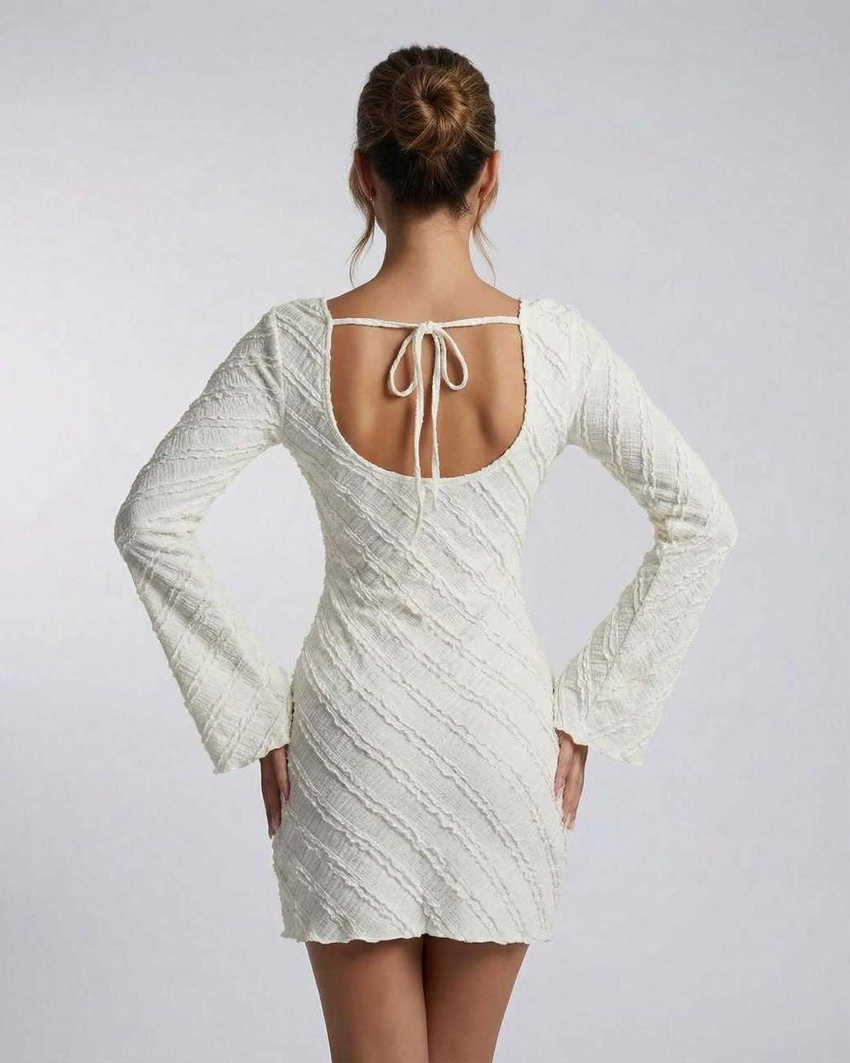 Sienna Mini Dress by Lauven showcasing the back view with a textured finish and long sleeves.