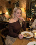 Verona Pullover by Lauven – Women’s brown off shoulder sweater styled at a cozy restaurant.