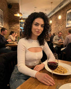 Monaco Top - Women’s White Long Sleeve Cut Out Top by Lauven, stylish and versatile in a cozy restaurant setting.