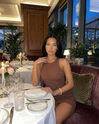 Arden Mini Dress by Lauven, brown ribbed knit sleeveless bodycon dress worn in a stylish dining setting.