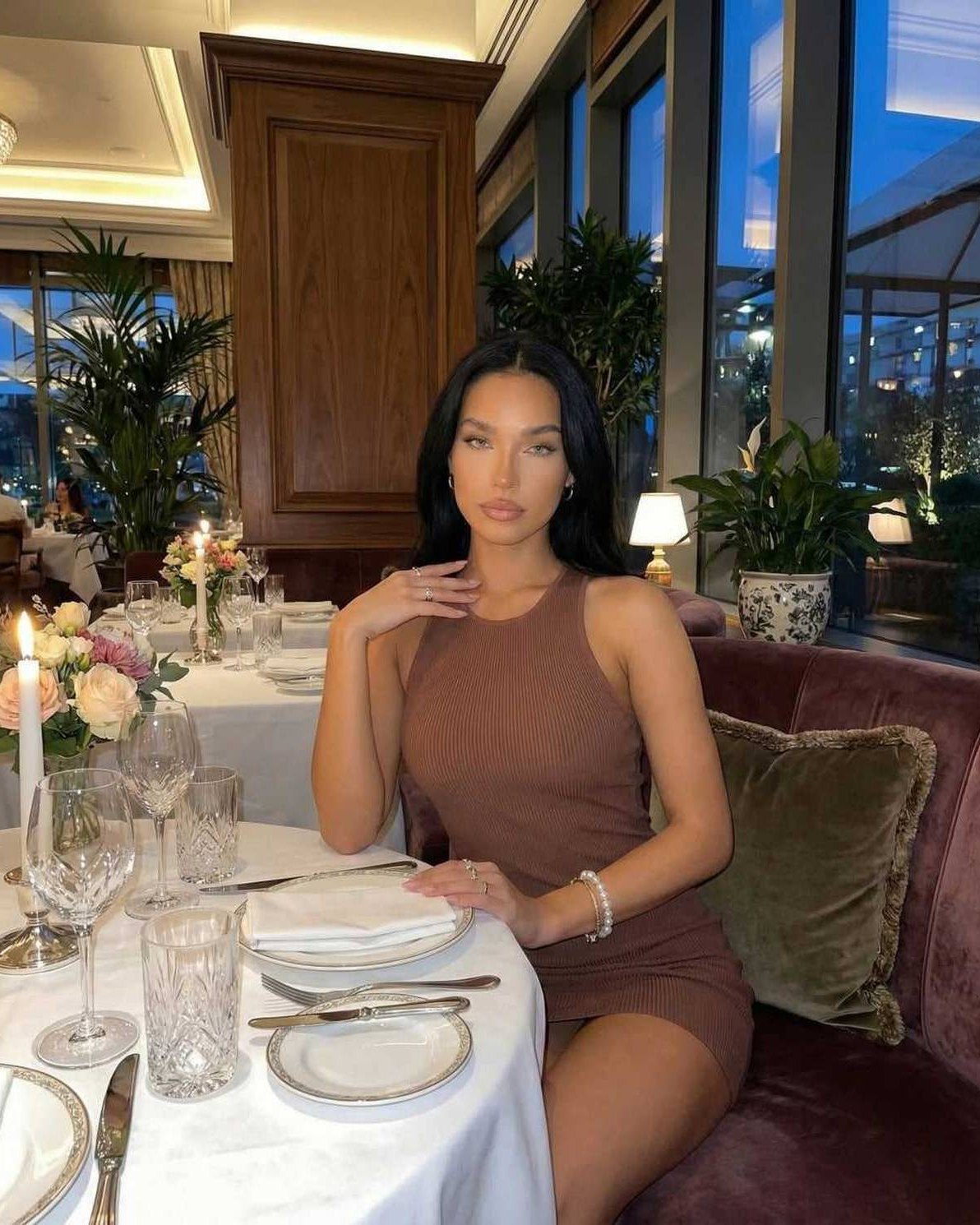 Arden Mini Dress by Lauven, brown ribbed knit sleeveless bodycon dress worn in a stylish dining setting.