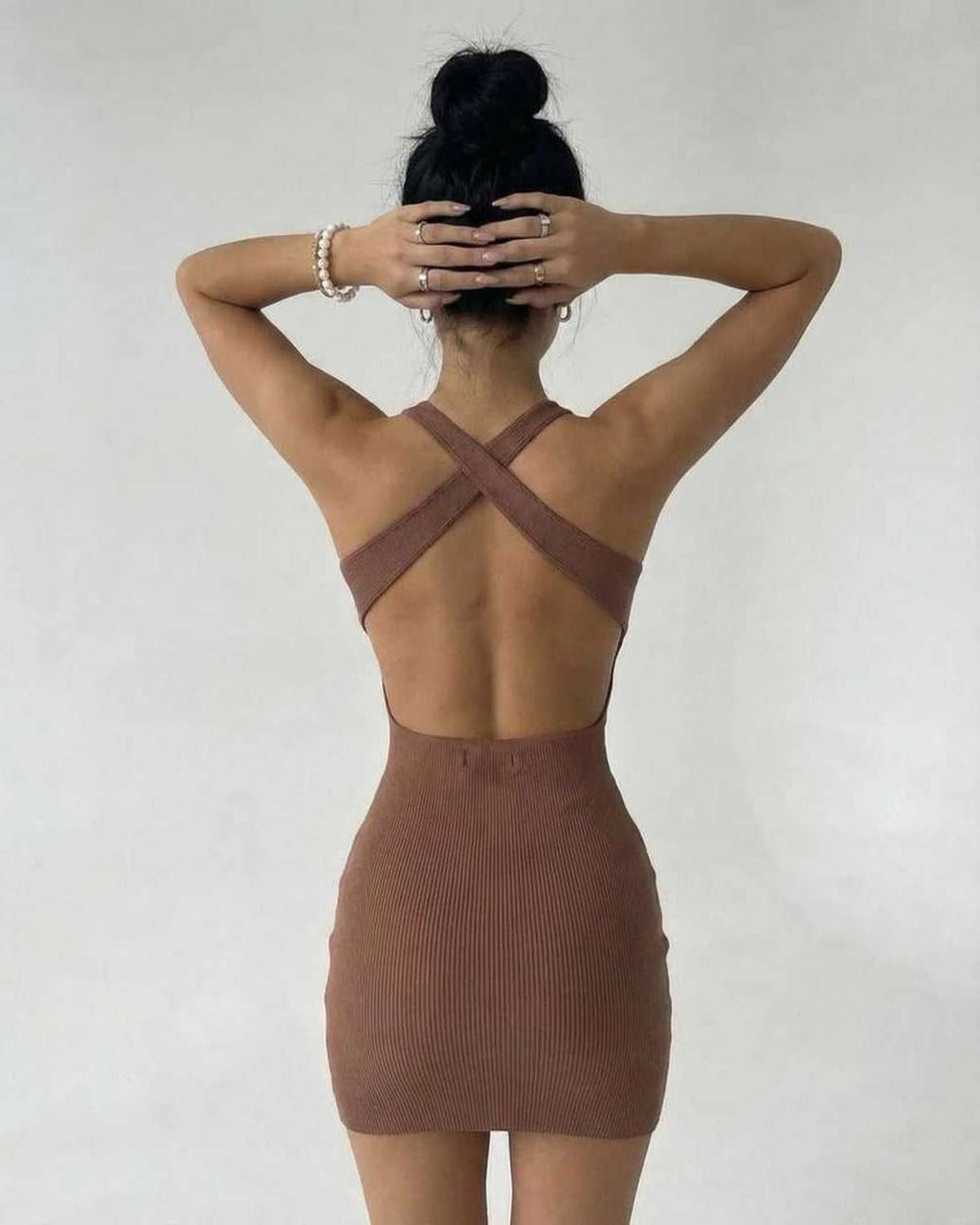Arden Mini Dress by Lauven featuring a back view of a brown ribbed knit sleeveless bodycon design.