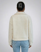 Back view of a woman wearing the Aspen Jacket by Lauven, showcasing its faux fur texture and structured design.