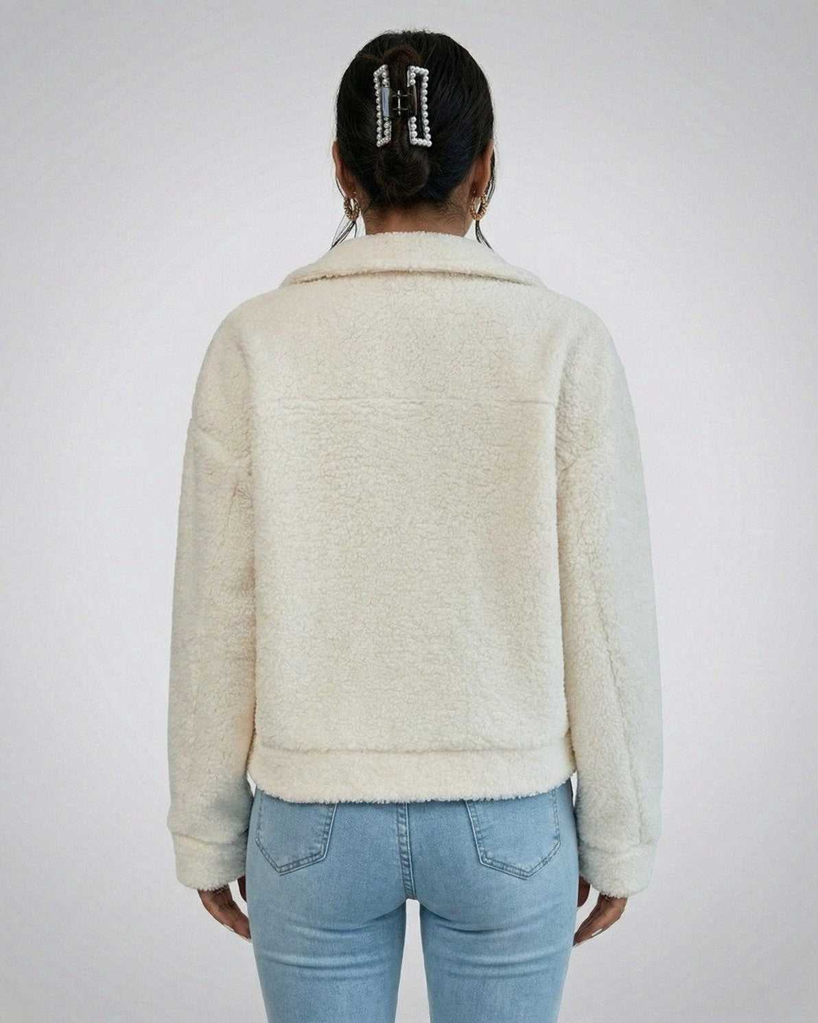 Back view of a woman wearing the Aspen Jacket by Lauven, showcasing its faux fur texture and structured design.