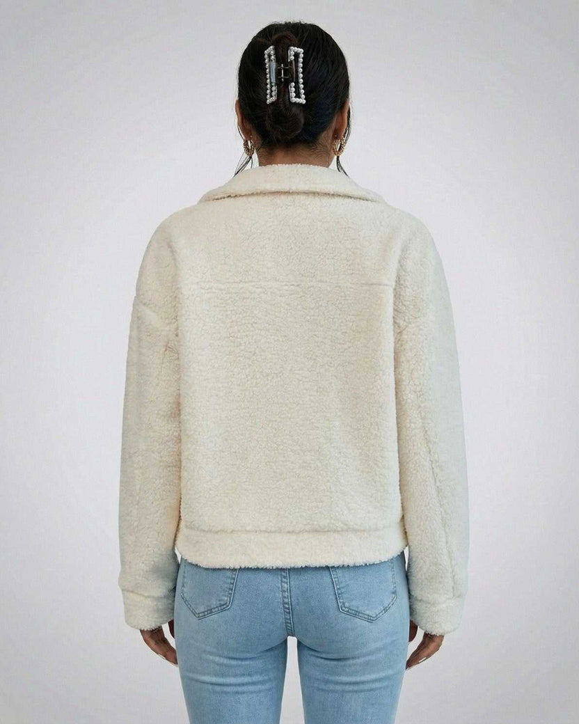 Back view of a woman wearing the Aspen Jacket by Lauven, showcasing its faux fur texture and structured design.