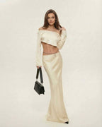 Model wearing the Aura Midi Dress by Lauven, featuring elegant satin finish in champagne, off-the-shoulder design.