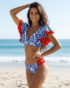 Lauven Azura Two-Piece Swimsuit featuring blue ornamental print and red accents at the beach.