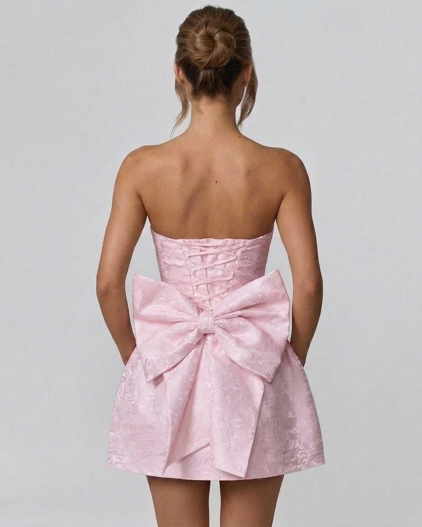 Blush Mini Dress by Lauven featuring a strapless neckline and elegant bow detail, showcasing its chic A-line silhouette.