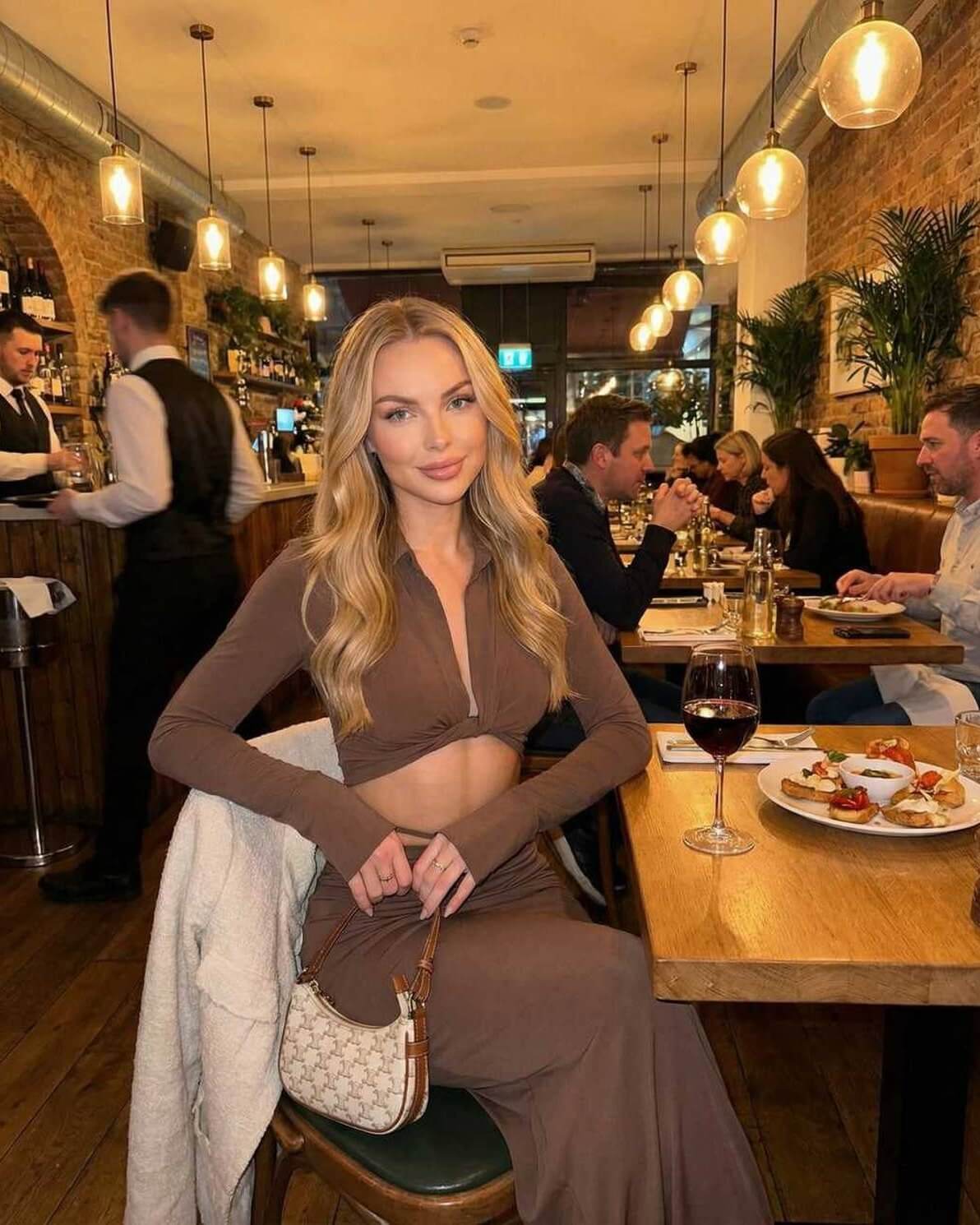Model wearing Calista Maxi Dress by Lauven, showcasing a chic dining scene with elegant style.