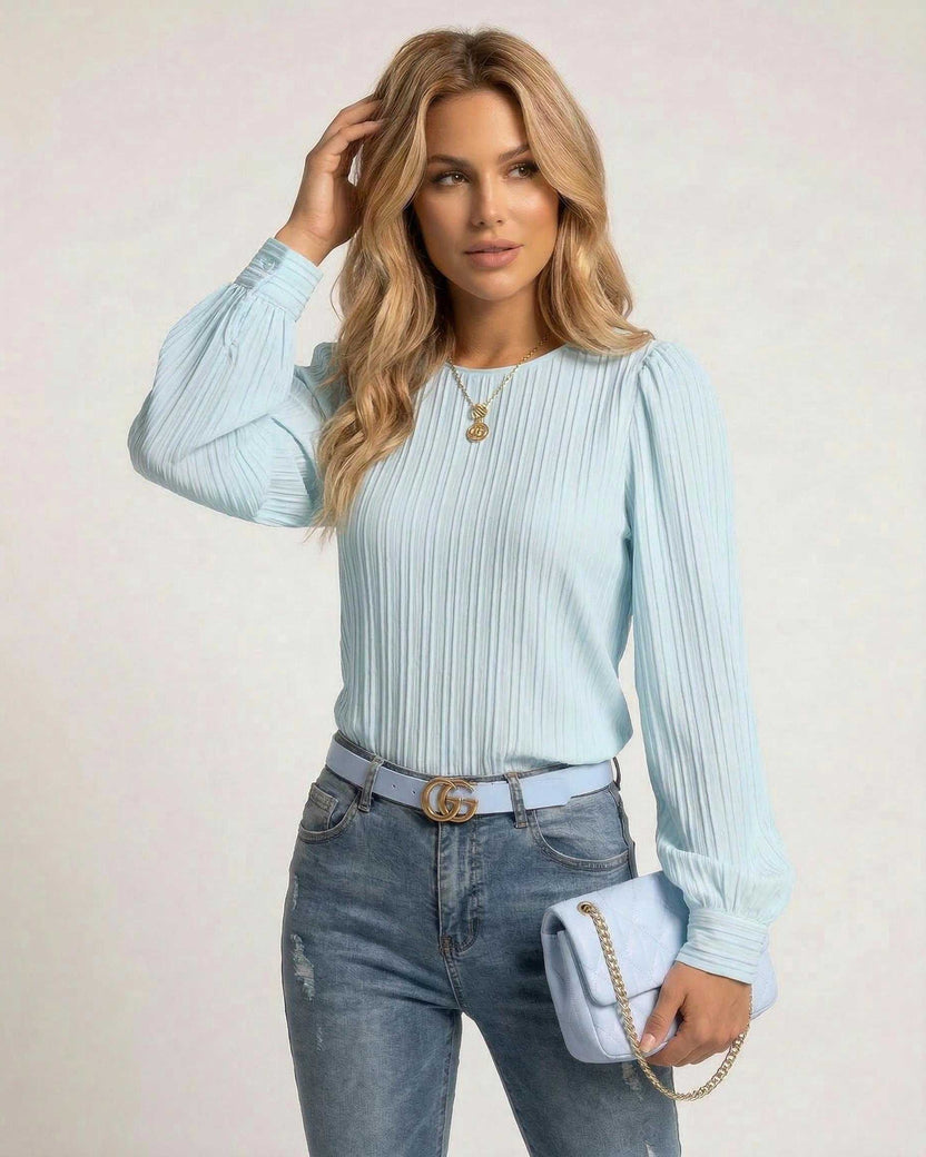 Celeste Blouse by Lauven - Elegant light blue pleated long sleeve top styled with jeans and a handbag.