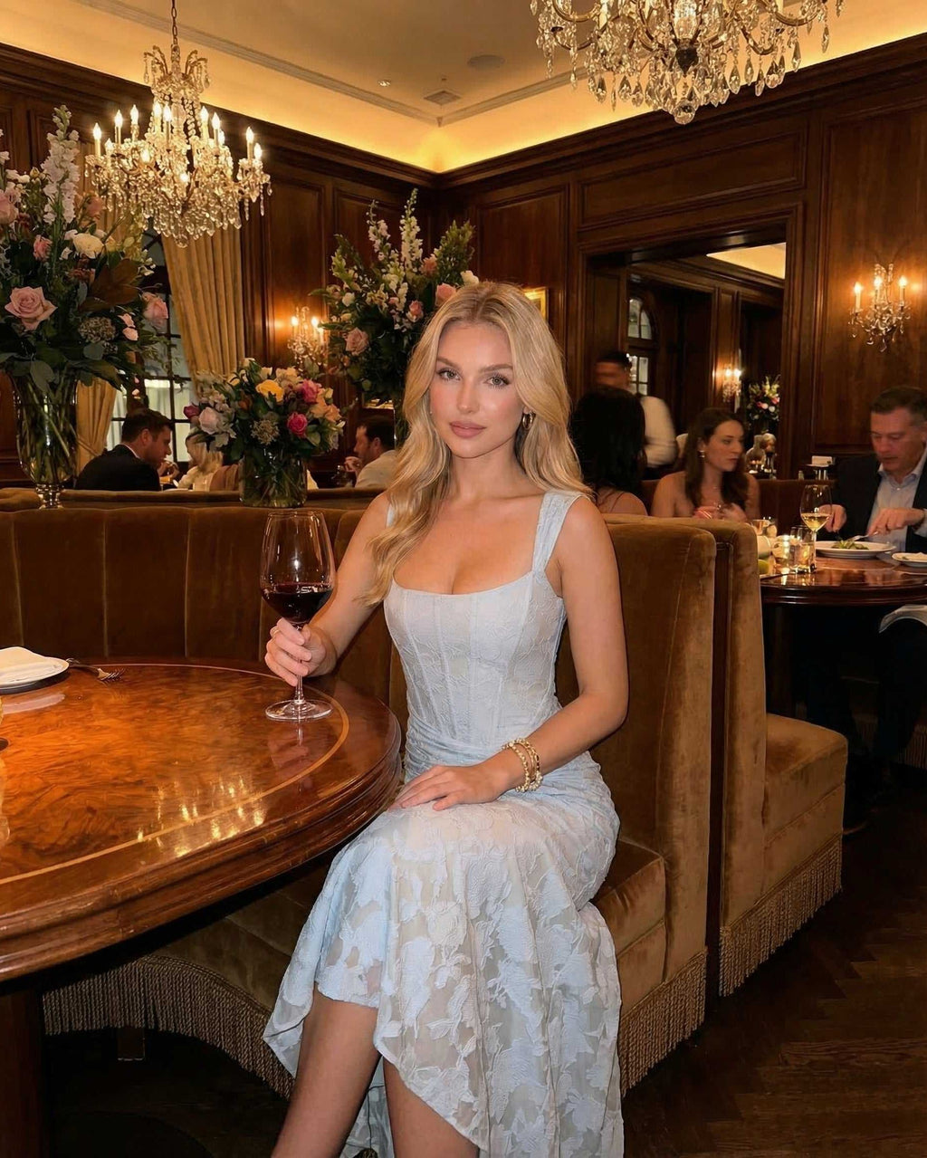 Woman in a Celeste Maxi Dress by Lauven, enjoying a drink at a stylish restaurant, surrounded by elegant decor.