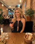 Celeste Maxi Dress by Lauven, elegant halter neck in black silhouette, worn while enjoying dinner.
