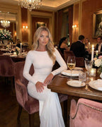Lauven Celeste Maxi Dress - Elegant white long sleeve maxi dress worn at a formal dinner setting.