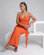 Model wearing the Celeste Maxi Dress by Lauven, featuring a bright orange spaghetti strap design and elegant silhouette.