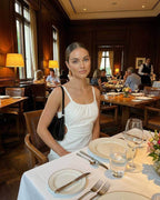Celeste Midi Dress by Lauven showcased in an elegant dining setting with stylish woman wearing it.
