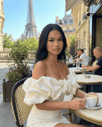Model wearing Celeste Mini Dress by Lauven, enjoying a coffee in Paris with the Eiffel Tower in the background.