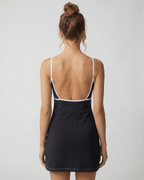 Back view of a model wearing the Celeste Mini Dress by Lauven, showcasing its sleek cut-out detail and flattering fit.