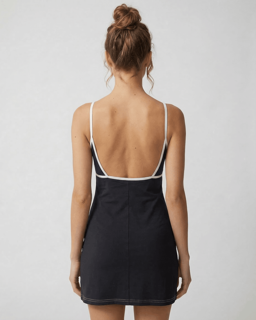 Back view of a model wearing the Celeste Mini Dress by Lauven, showcasing its sleek cut-out detail and flattering fit.