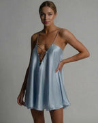 Model wearing Lauven's Celestial Mini Dress in icy blue satin, featuring a flared A-line silhouette and beaded spaghetti straps.