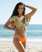 Lauven Citrus Two-Piece Swimsuit with vibrant floral and citrus prints, deep V-neck, and bold orange panels at the beach.