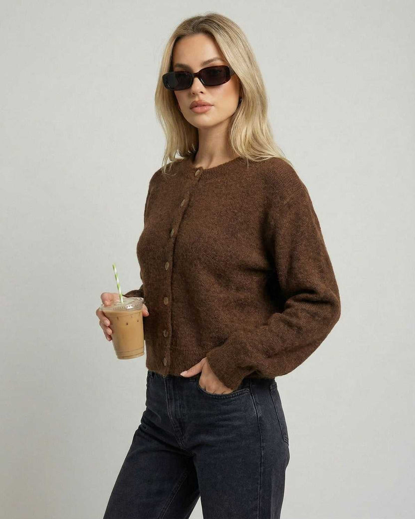 Cocoa Cardigan by Lauven modeled by a woman holding a drink, showcasing its button-front design and relaxed fit.