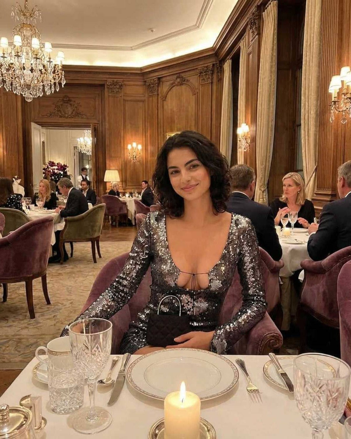 Elegant woman in Lauven Eestella Mini Dress with sequined shine, flared sleeves, dining in a luxurious restaurant.