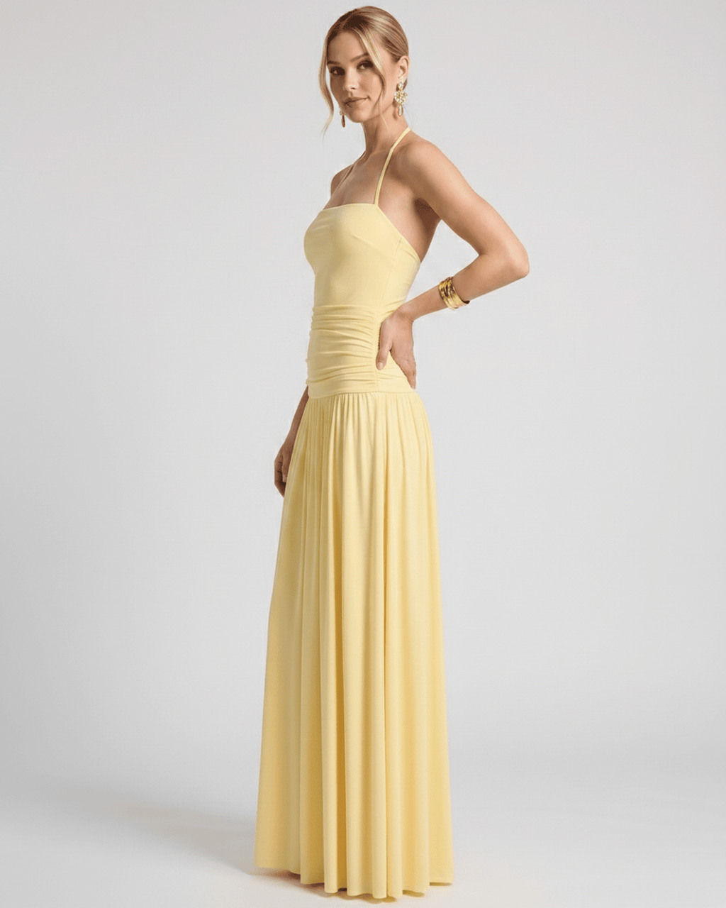 Elara Maxi Dress in yellow stretch jersey, halter neck design, featuring a ruched waist and flowing skirt for effortless elegance.