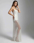 Elara Maxi Dress featuring a white sequin design with strappy back and sheer overlay for a luminous look.