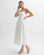 Elara Midi Dress in white with strapless design and pleated skirt, showcasing refined elegance by Lauven.