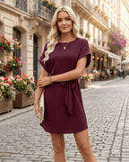 Elara Mini Dress in burgundy, featuring smooth woven fabric, round neckline, and self-tie waist belt by Lauven.