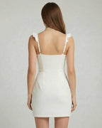 Elara Mini Dress - Back view showcasing ruffle trim and fitted design by Lauven in a clean white finish.