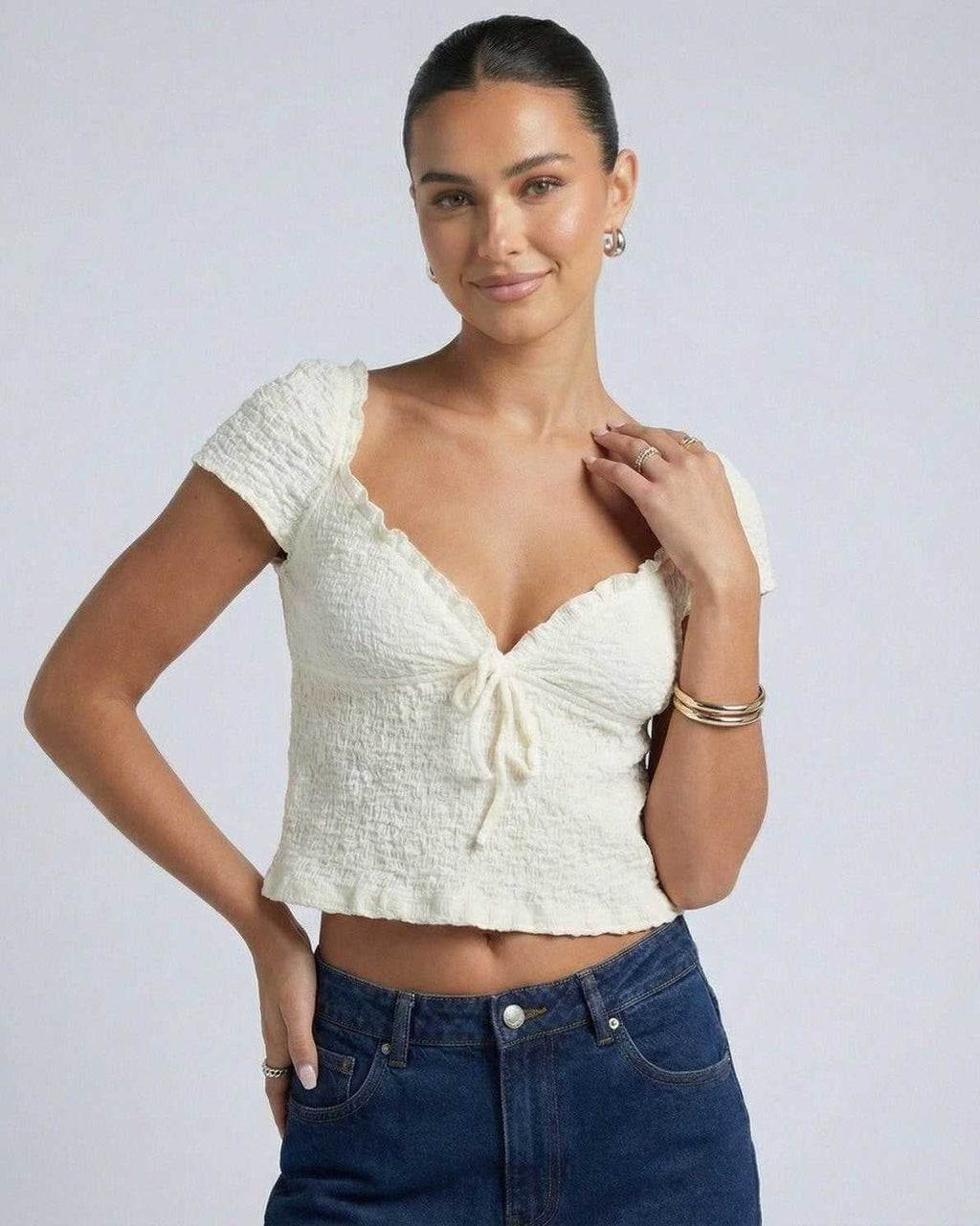 Elara Tie Top by Lauven, a ruched V-neck crop blouse with a feminine tie detail and short sleeves.