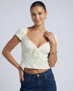 Elara Tie Top by Lauven, a ruched V-neck crop blouse with a feminine tie detail and short sleeves.