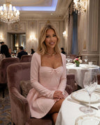 Elvire Mini Dress displayed in a luxurious setting, showcasing the light pink long sleeve fit-and-flare design by Lauven.