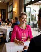 Fiora Mini Dress by Lauven in hot pink on a woman dining elegantly at a restaurant.