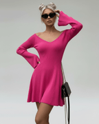 Model wearing Fiora Mini Dress by Lauven, a slim fit pink knit dress with V-neck and flared sleeves.
