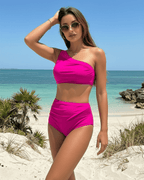Fuchsia Two-Piece Swimsuit by Lauven on a beach, featuring a stylish asymmetric design and vibrant fuchsia color.