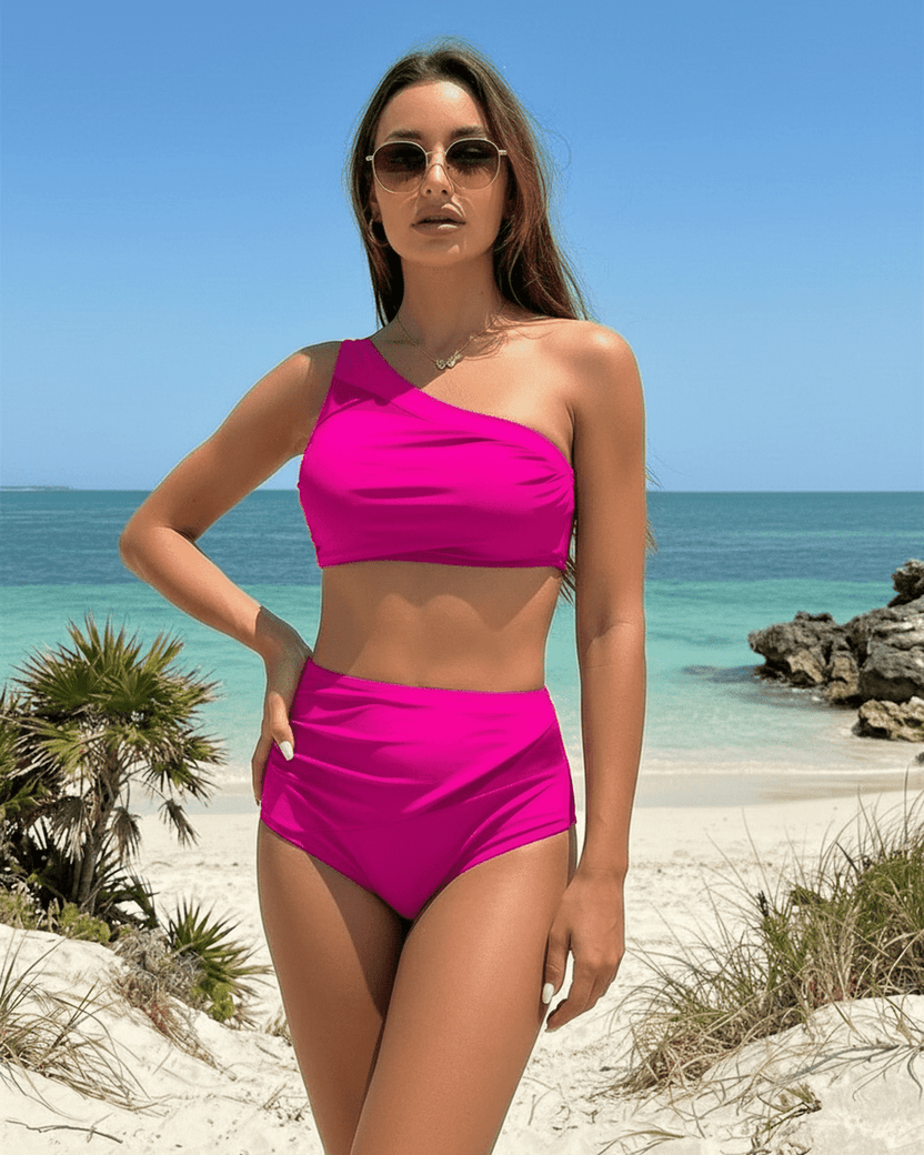 Lauven Fuchsia Two-Piece Swimsuit on model at beach, featuring one-shoulder design and breathable cotton fabric.