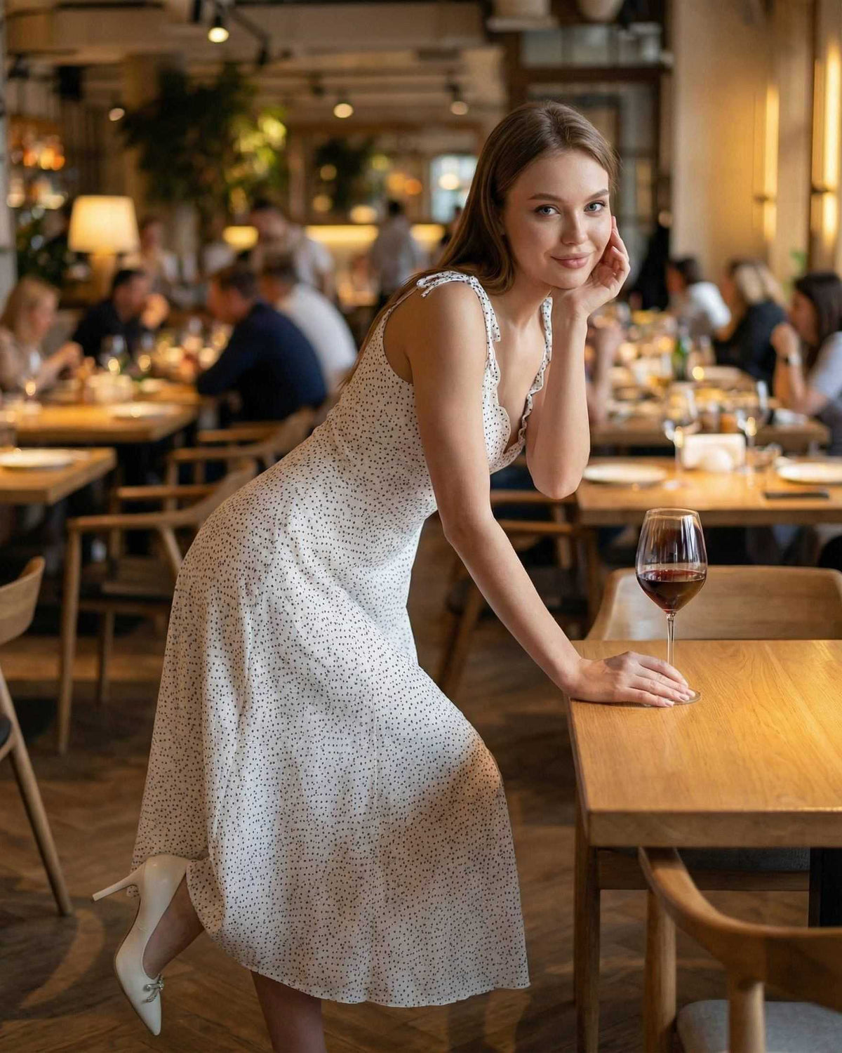 Elara Midi Dress by Lauven, featuring elegant polka dot detail, worn by a woman in a chic dining setting.