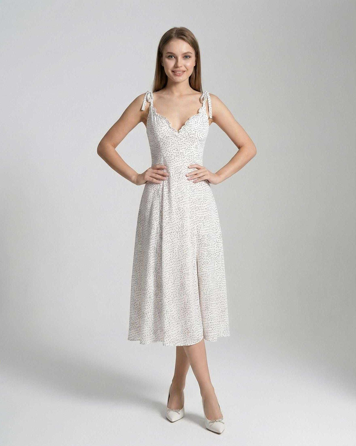 Elara Midi Dress by Lauven features a sleeveless A-line silhouette with polka dot detail, showcasing elegance and femininity.