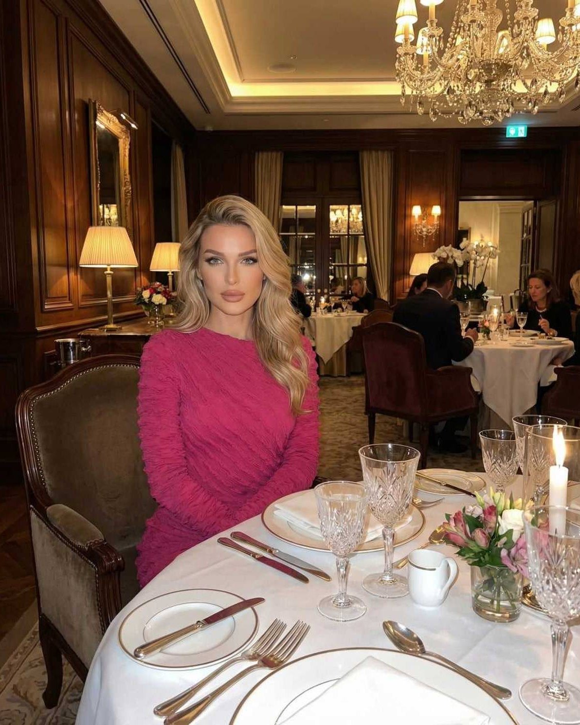 Isla Maxi Dress by Lauven, a textured pink long sleeve knitted maxi dress, elegantly worn at a dining table.