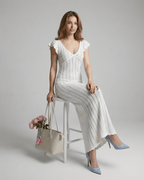 Model wearing the Ivory Lace Maxi from Lauven, showcasing a white cotton V-neck bodycon dress with ruffle sleeves.