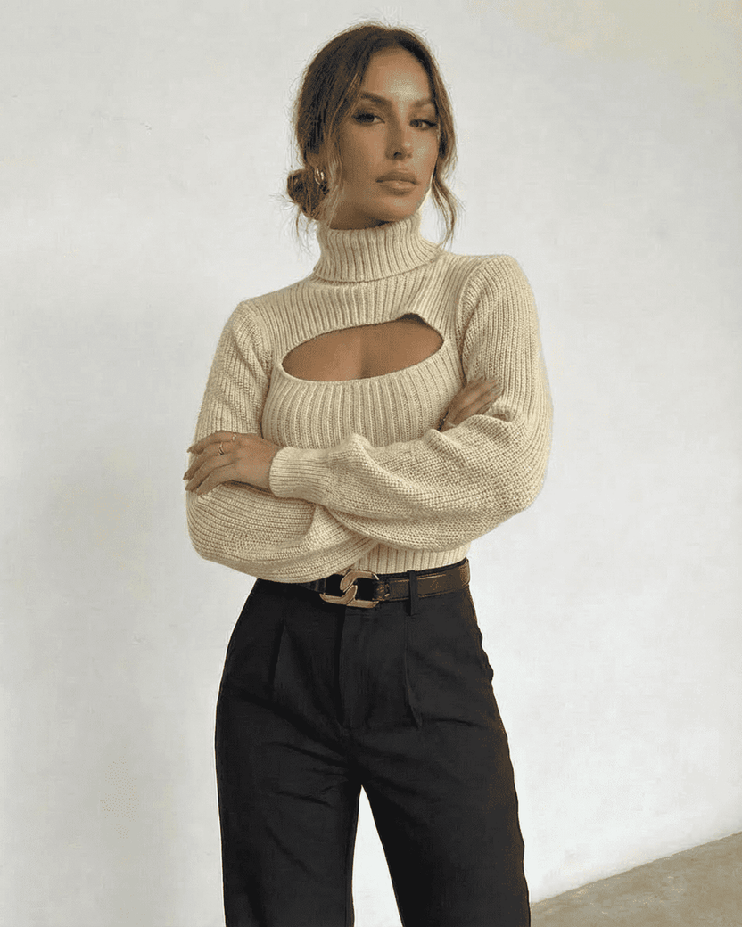 Ivory Sweater by Lauven featuring a mock neck and cut out detail on a model styled with high-waisted trousers.