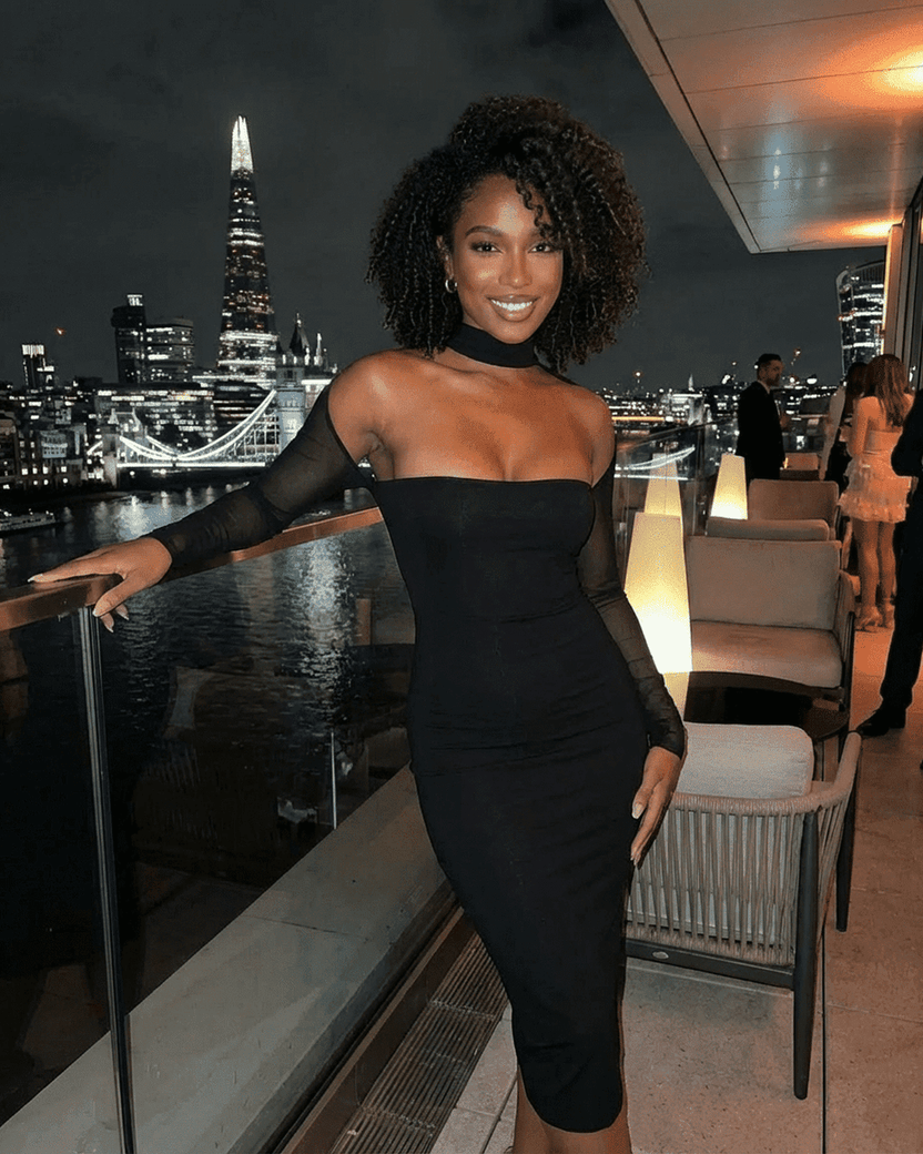 Arden Midi Dress by Lauven showcased in a chic evening setting with city skyline background.
