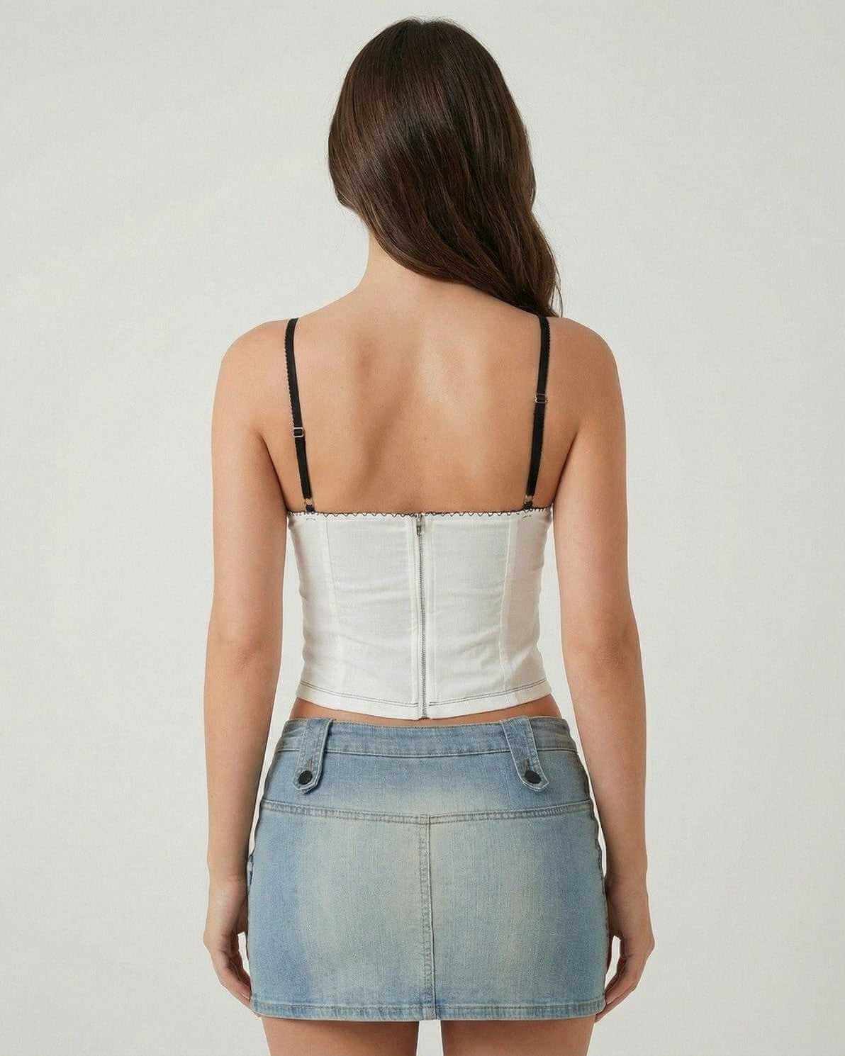 Back view of a woman wearing the Arden Top by Lauven, showcasing its white fabric and black straps.