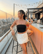 Bianca Mini Skirt by Lauven, white sequin A-line bodycon mini skirt, styled in a chic summer rooftop setting.
