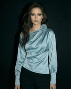 Celeste Blouse by Lauven, showcasing an asymmetrical satin-style design with long sleeves and a floral detail.