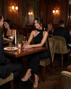 Celeste Maxi Dress by Lauven - Sleek black halter neck evening dress worn in a sophisticated restaurant setting.