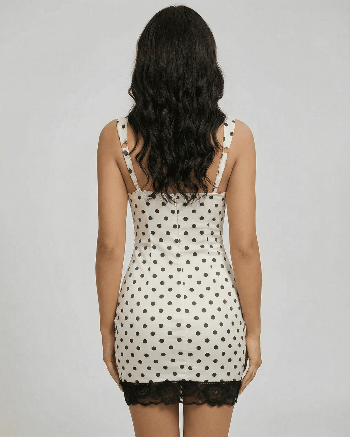 Back view of the Celeste Mini Dress by Lauven, featuring polka dots, lace trim, and a fitted silhouette.